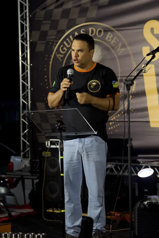 Pregador falando ao microfone no palco