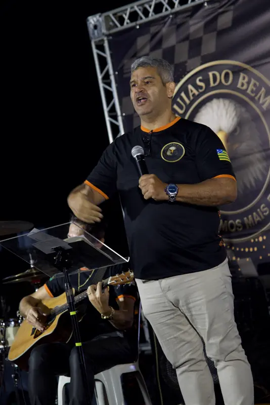 Palestrante no palco com banda ao fundo