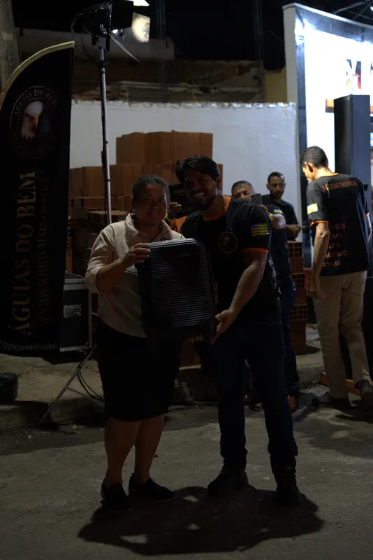 Voluntário entregando prêmio a uma participante