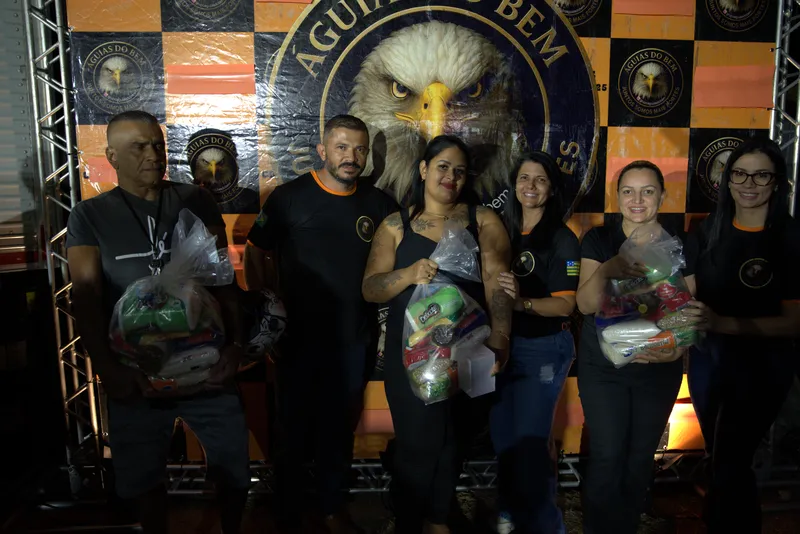 Voluntários e participantes com cestas básicas