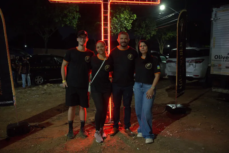 Voluntários diante da cruz iluminada