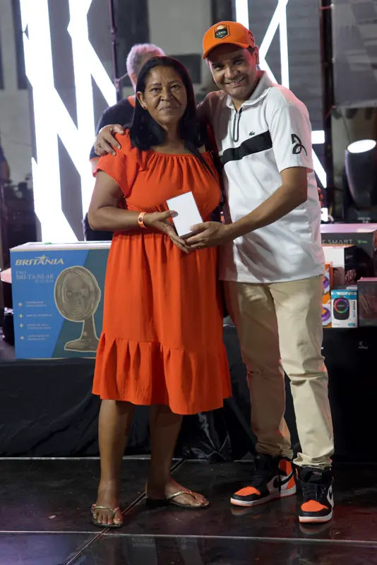 Entrega de prêmio a uma participante no palco