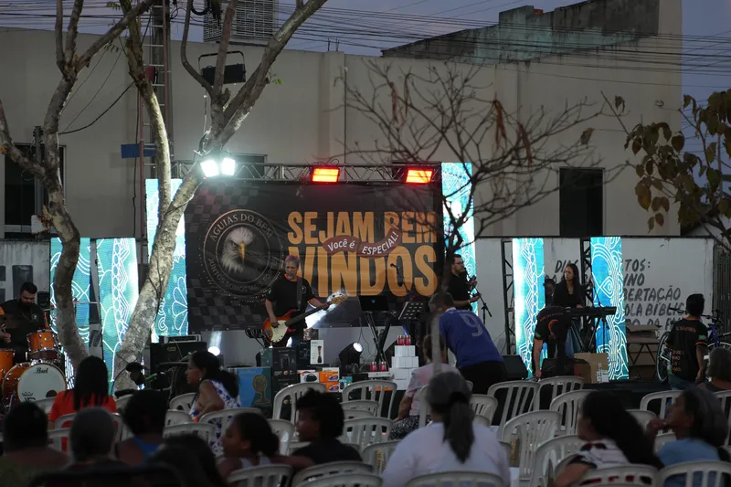 Palco da ação ao entardecer com a banda e o público chegando