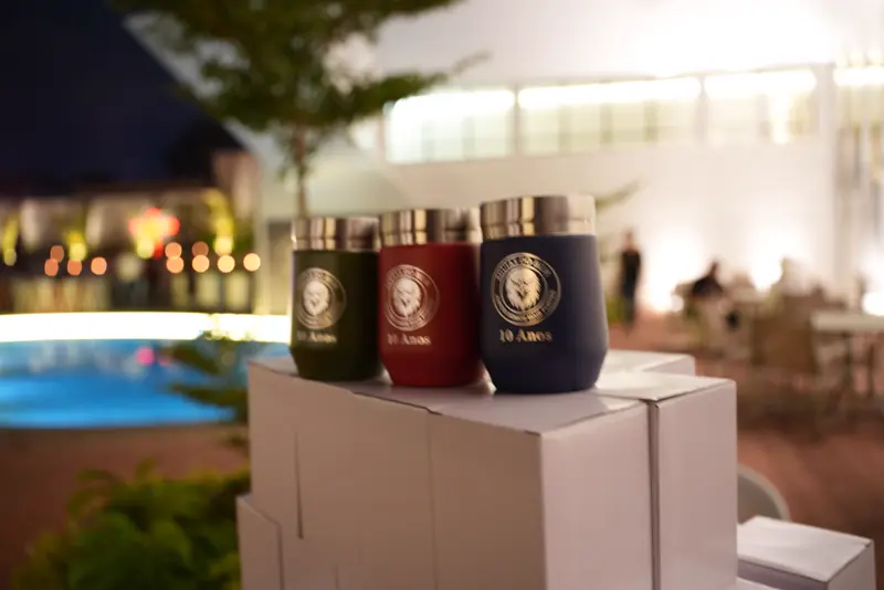 Copos térmicos com o emblema do grupo à beira da piscina