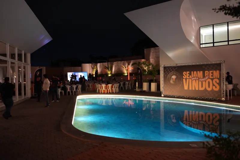 Piscina iluminada e banner de boas-vindas no local do evento