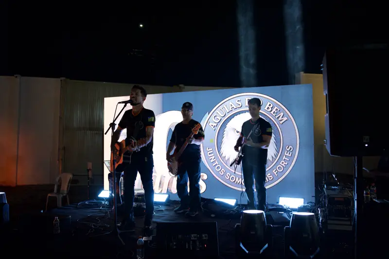 Banda no palco em frente ao emblema do Águias do Bem