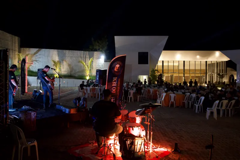 Visão geral do evento à noite com palco e convidados