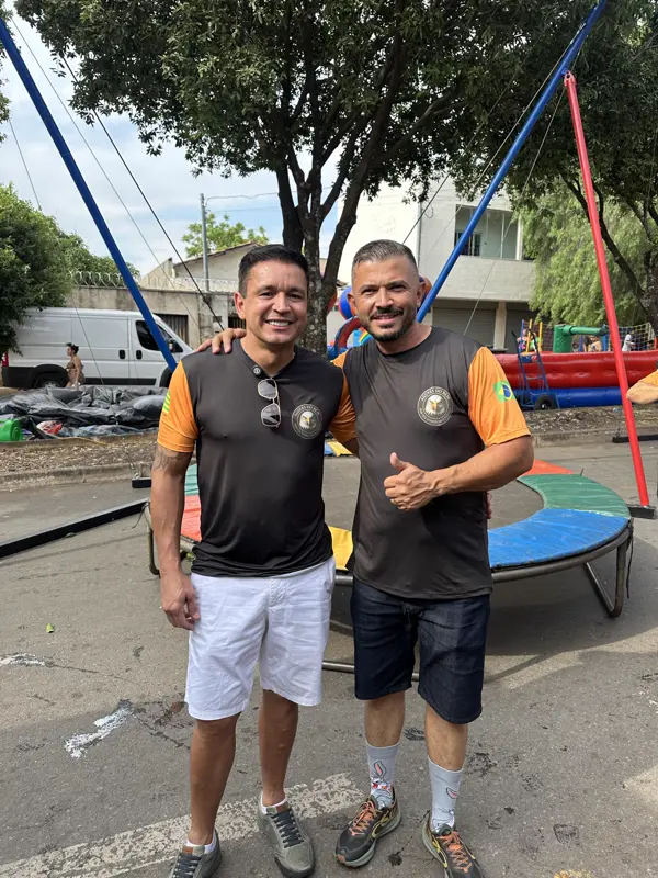 Dois voluntários do grupo sorrindo na área dos brinquedos