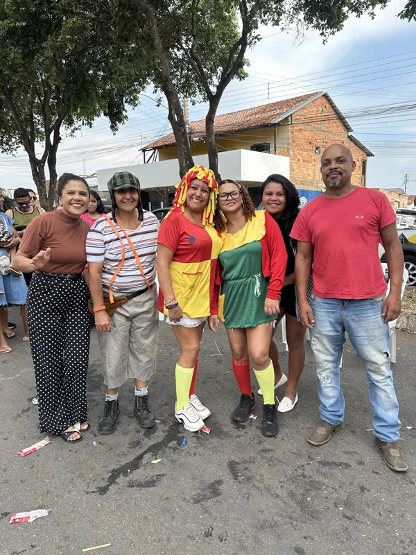 Adultos e palhaços reunidos na rua durante a festa