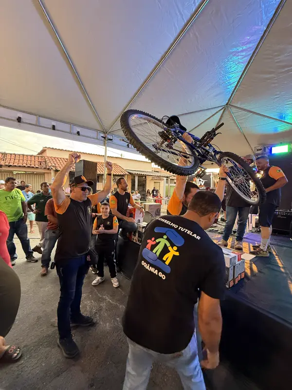 Voluntário erguendo uma bicicleta sob a tenda