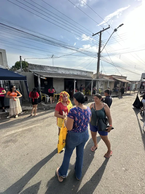 Palhaça conversando com moradoras na rua da festa