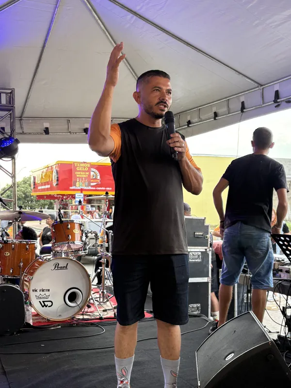 Voluntário falando ao público no palco