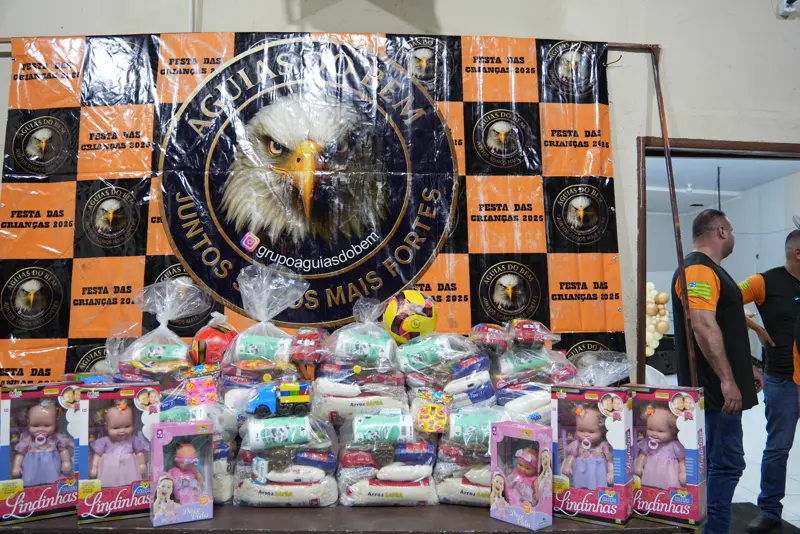 Kits e brinquedos diante do banner das Águias do Bem