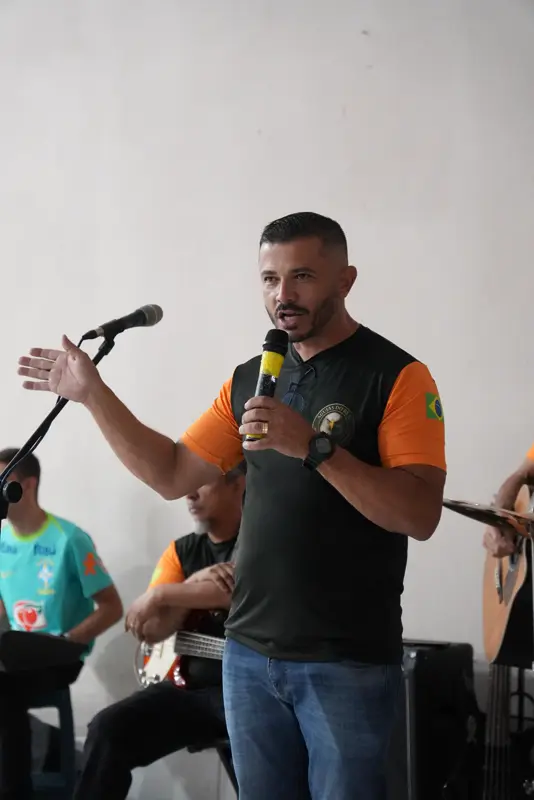 Voluntário falando ao microfone durante o encontro