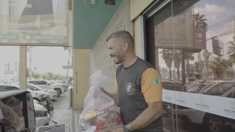 Voluntário com sacolas na entrada da clínica