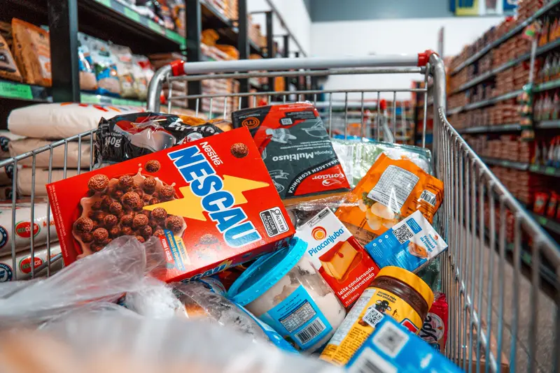 Carrinho de supermercado cheio de alimentos para a ação de Natal