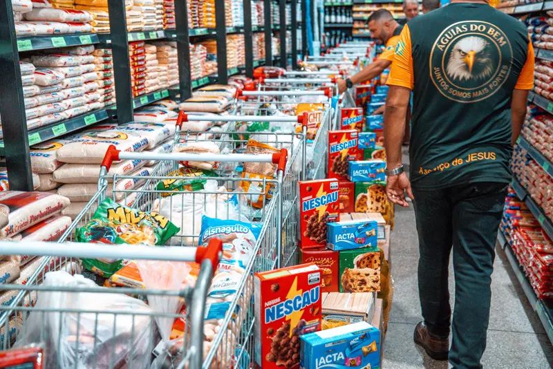 Voluntário das Águias do Bem organizando carrinhos de compras